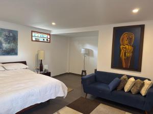 a bedroom with a bed and a blue couch at Casa campestre VALLE ESCONDIDO in Cómbita