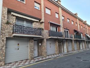 un edificio de ladrillo con dos puertas de garaje en una calle en Can Tete, en Malgrat de Mar