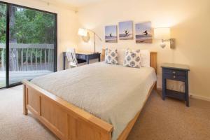 a bedroom with a bed and a desk and a window at 611 Magnolia-Stella Maris in Edisto Island