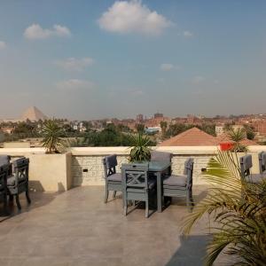 a patio with a table and chairs on a roof at Pyramids Oasis Hotel - Giza in Cairo
