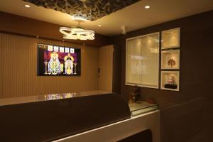 a bathroom with a sink and a tv on the wall at Giri Comfort in Tiruvannāmalai