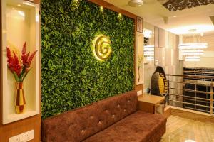 a large green wall with a couch in a lobby at Giri Comfort in Tiruvannāmalai