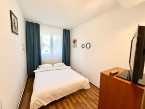 a small bedroom with a bed and a television at Berzei Astra - Rise Apartments in Braşov