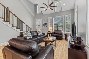 a living room with a leather couch and a table at Luxury 2 bedroom Townhouse #5 in Prien