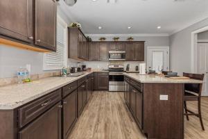 a large kitchen with wooden cabinets and stainless steel appliances at Luxury 2 bedroom Townhouse #5 in Prien