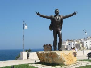 a statue of a man with his arms out at Appartamento Onda Marina in Polignano a Mare