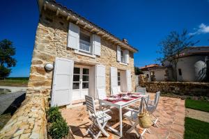 a stone house with a table and chairs at La Casita - Casa encantadora en Carriazo, Ribamontan al Mar, Cantabria in Carriazo