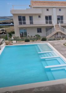 a large swimming pool in front of a house at Ortensia Apartment in Pachino