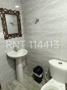 a bathroom with a toilet and a sink and a mirror at Apartamento Nomadas in Santa Rosa de Cabal +10 photos