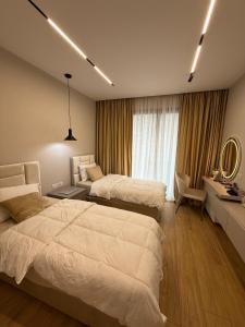a bedroom with two beds and a desk with a mirror at Coral's Luxury Seaview Apartment in Vlorë