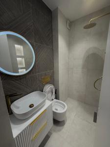 a bathroom with a toilet and a sink and a mirror at Coral's Luxury Seaview Apartment in Vlorë +10 photos