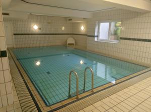 a large swimming pool in a tiled room at Apartment Pool Sauna Netflix Bike Parking WIFI YTPremium in Zwiesel