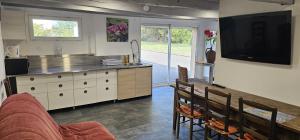 a living room with a kitchen and a tv at Domaine Normence en Baie du Mont St Michel in Marcilly