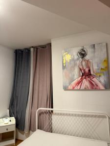 Un dormitorio con un cuadro de una mujer con un vestido rosa. en Babylon, en Stuttgart