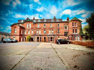 a large brick building with cars parked in front of it at Green Gables Hotel in Scarborough