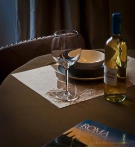 un tavolo con un bicchiere di vino e una bottiglia di vino di The View of Roma a Roma