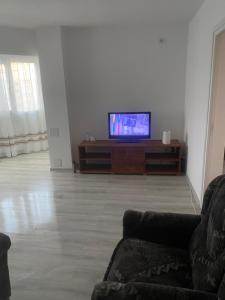 a living room with a couch and a flat screen tv at Ploiesti-Republicii RH in Ploieşti