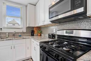 a kitchen with a black stove and white cabinets at Sophisticated Boho Condo Walkable Columbus in Columbus