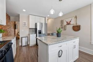 a kitchen with white cabinets and a counter top at Sophisticated Boho Condo Walkable Columbus in Columbus +7 photos