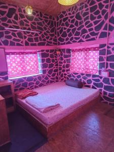 a room with a bed in a room with pink lights at PINK HOUSE DORMENTRY Vattakanal in Kodaikānāl