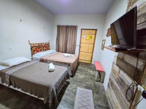 a room with two beds and a flat screen tv at Hotel Urumajó in Augusto Correa