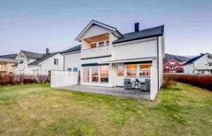 ein großes weißes Haus mit einem großen Garten in der Unterkunft Unique house next to the sea in Tromsø