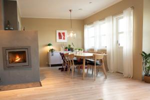 ein Esszimmer mit Tisch und Kamin in der Unterkunft Unique house next to the sea in Tromsø