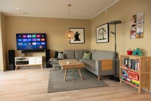 ein Wohnzimmer mit Sofa und Fernseher in der Unterkunft Unique house next to the sea in Tromsø