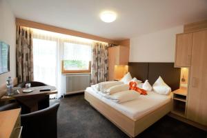 una habitación de hotel con una cama con un osito de peluche. en Frühstückspension Rehwinkl, en Sölden