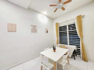 a dining room with a white table and a ceiling fan at Ipoh Seri Botani 5br22 pax bbq mahjong in Kampong Kepayang