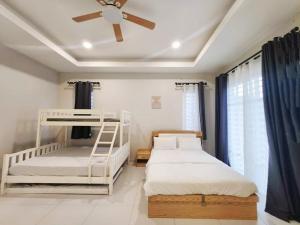 a bedroom with two bunk beds and a ceiling fan at Ipoh Seri Botani 5br22 pax bbq mahjong in Kampong Kepayang