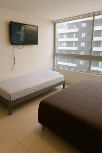Un dormitorio con una cama y un televisor de pantalla plana. en Depto estudio en excelente ubicación, en Santiago