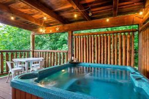 eine Whirlpool-Badewanne auf einer Terrasse mit einem Tisch in der Unterkunft Smokies Getaway Special! Hot Tub, Games, Views & just 4 miles to Pigeon Forge! in McCookville + 56 Fotos