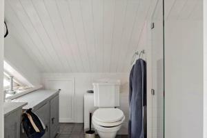 Un baño blanco con inodoro y ducha. en BOH651-Kaeringoen-Kosen-560, en Käringön 12 fotos más