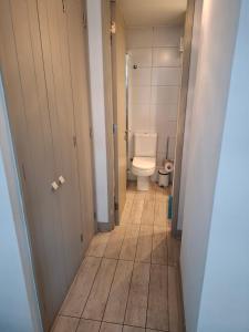 Un pequeño baño con inodoro y un pasillo. en Depto estudio en excelente ubicación, en Santiago