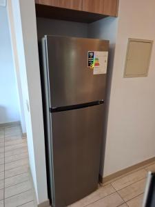 Un refrigerador de acero inoxidable en una cocina. en Depto estudio en excelente ubicación, en Santiago