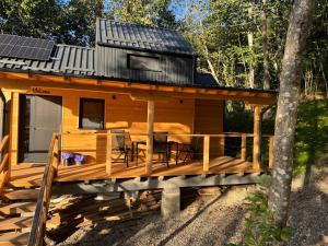 a cabin with a deck with a solar roof at Cabana Forest LakeView Potoci in Potoci