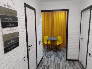 Habitación con mesa y 2 sillas amarillas en Квартира посуточно в Шахтинске, en Shakhtīnsk