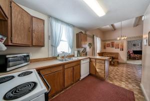 a kitchen with wooden cabinets and a white stove top oven at 4BR Near Ski Cooper Mineral Belt - Pet Friendly in Leadville