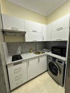 a kitchen with a sink and a washing machine at La-Quinta Resort Erika in Hurghada