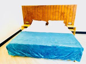 a bed with a blue blanket on top of it at Araess Homestay Karatu in Karatu