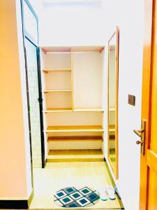 a room with a closet with shelves and a door at Araess Homestay Karatu in Karatu