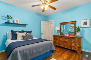 a blue bedroom with a bed and a mirror at Cozy Retreat, Steps to Yale Bridgeport Hospital in Bridgeport