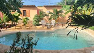 a swimming pool with chairs and a table in a yard at Villa mit Pool in Mbour in Mbour