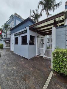 a white building with a gate and a fence at Apartamento de 1 quarto !! in Joinville