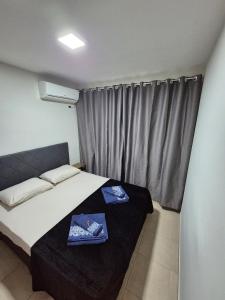 a bedroom with a bed with two towels on it at Apartamento de 1 quarto !! in Joinville