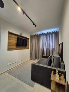 a living room with a large bed and a flat screen tv at Apartamento de 1 quarto !! in Joinville