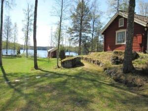 a red house in the middle of a yard with a tree at ORE742-Granbergsdal-Dalsmund-Arvidsudden-780 in Lersjötorp +14 photos