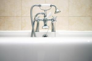 eine Badewanne mit Wasserhahn und Waschbecken in der Unterkunft BURLINGTON LUXURY APARTMENT- SLEEPS 6- SUPER FAST WiFi- PRIVATE PARKING SPACE- FLAT SCREEN SMART TV- FREE ONSITE GYM- 1 MIN DRIVE TO BOSCOMBE PIER- GREAT LOCATION! in Bournemouth + 41 Fotos
