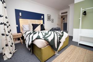 ein Schlafzimmer mit einem großen Bett mit blauem Kopfteil in der Unterkunft BURLINGTON LUXURY APARTMENT- SLEEPS 6- SUPER FAST WiFi- PRIVATE PARKING SPACE- FLAT SCREEN SMART TV- FREE ONSITE GYM- 1 MIN DRIVE TO BOSCOMBE PIER- GREAT LOCATION! in Bournemouth